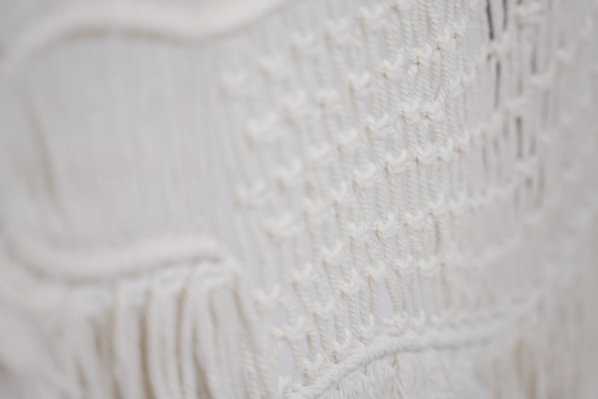 Close-up of the macrame wall hanger photographed against a neutral background showcasing the design