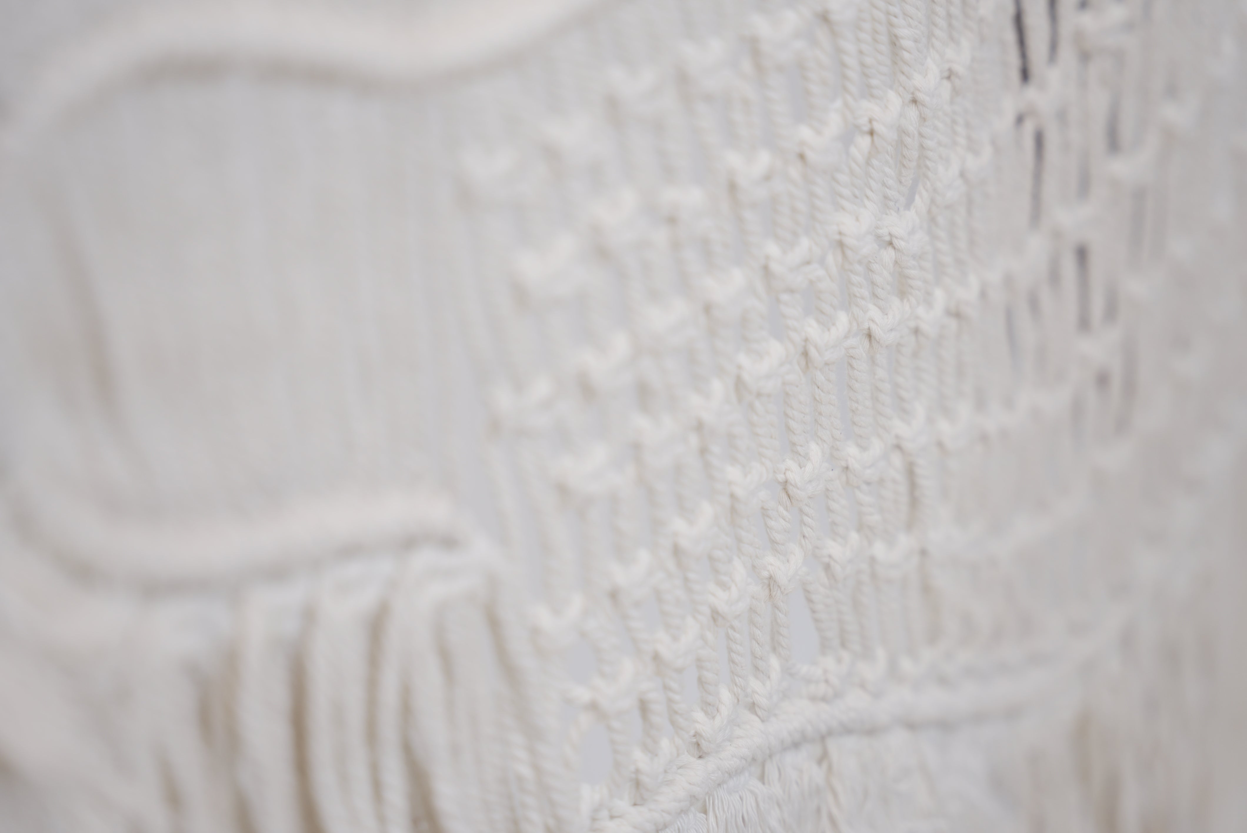 Close-up of the macrame wall hanger photographed against a neutral background showcasing the design