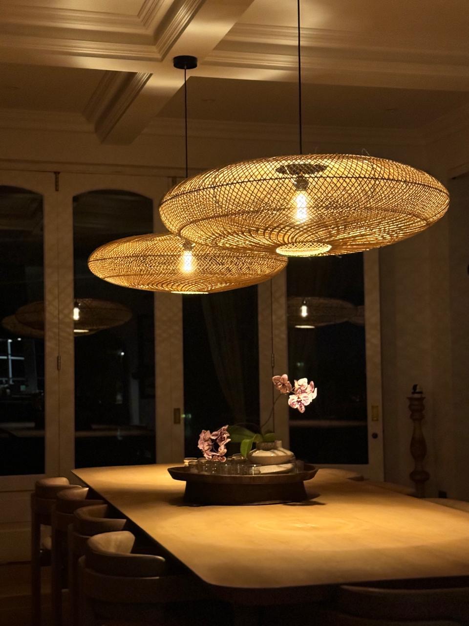 Two UFO pendants hanging above a table in a moody setting