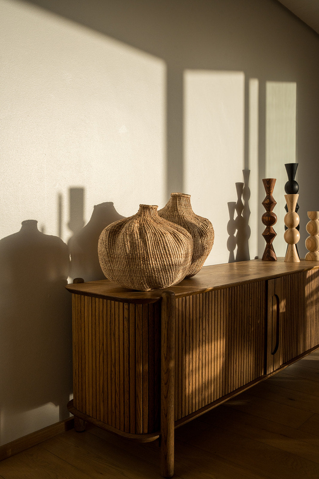 Two of the garlic gourds photographed on a side table with afternoon sun on them