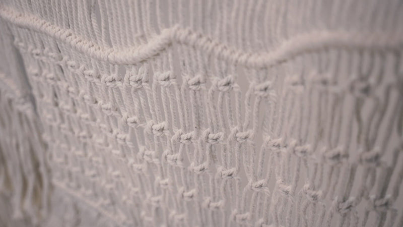 Close-up of the macrame wall hanger photographed against a neutral background showcasing the design