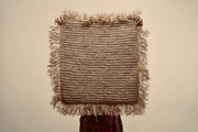 The Raffia cushion cover held up by a person to showcase the size of it