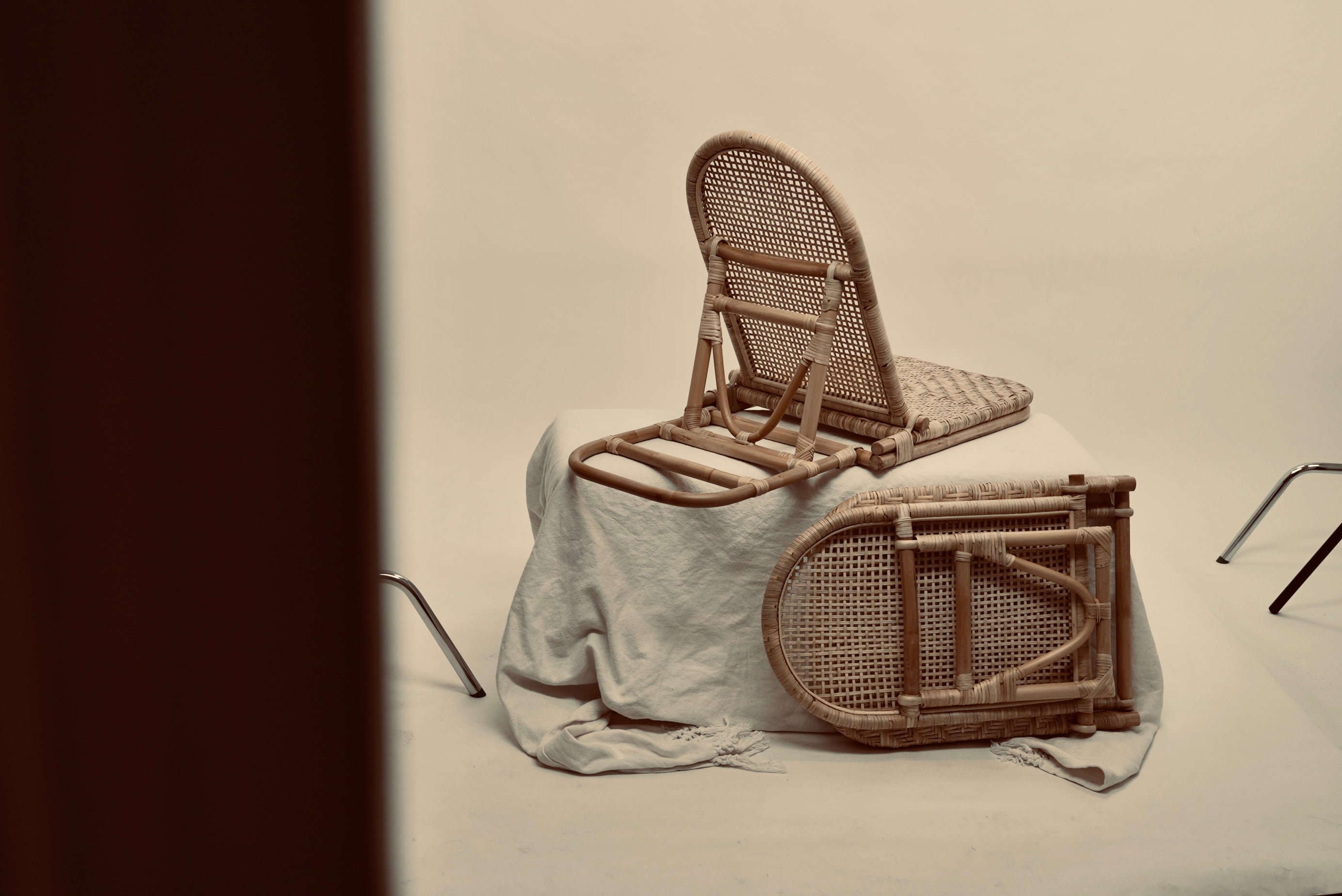 The foldup Rattan beach chair photographed from behind and folded up against a neutral background