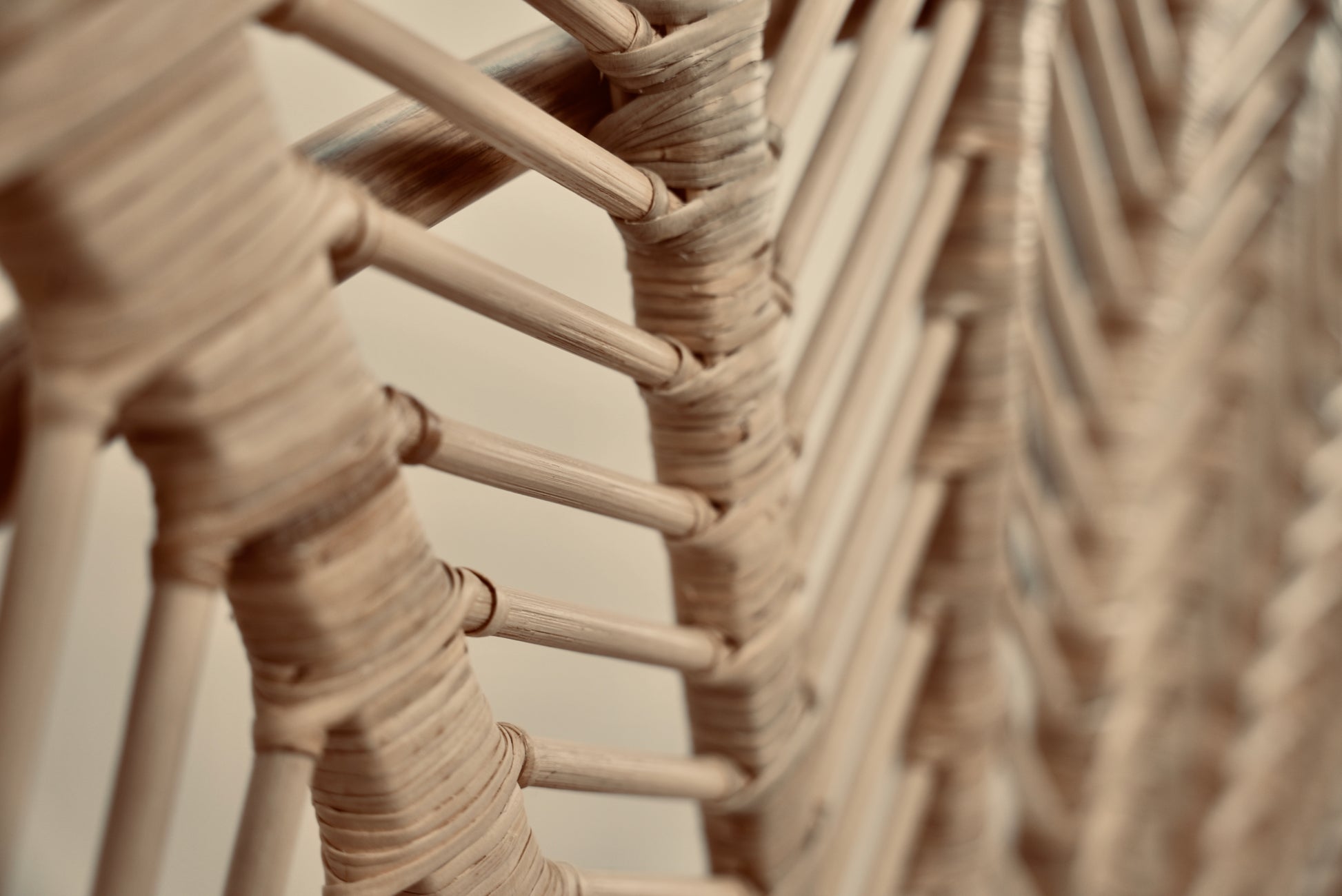 A close-up of the Rattan Ibu headboard photographed against a neutral headboard