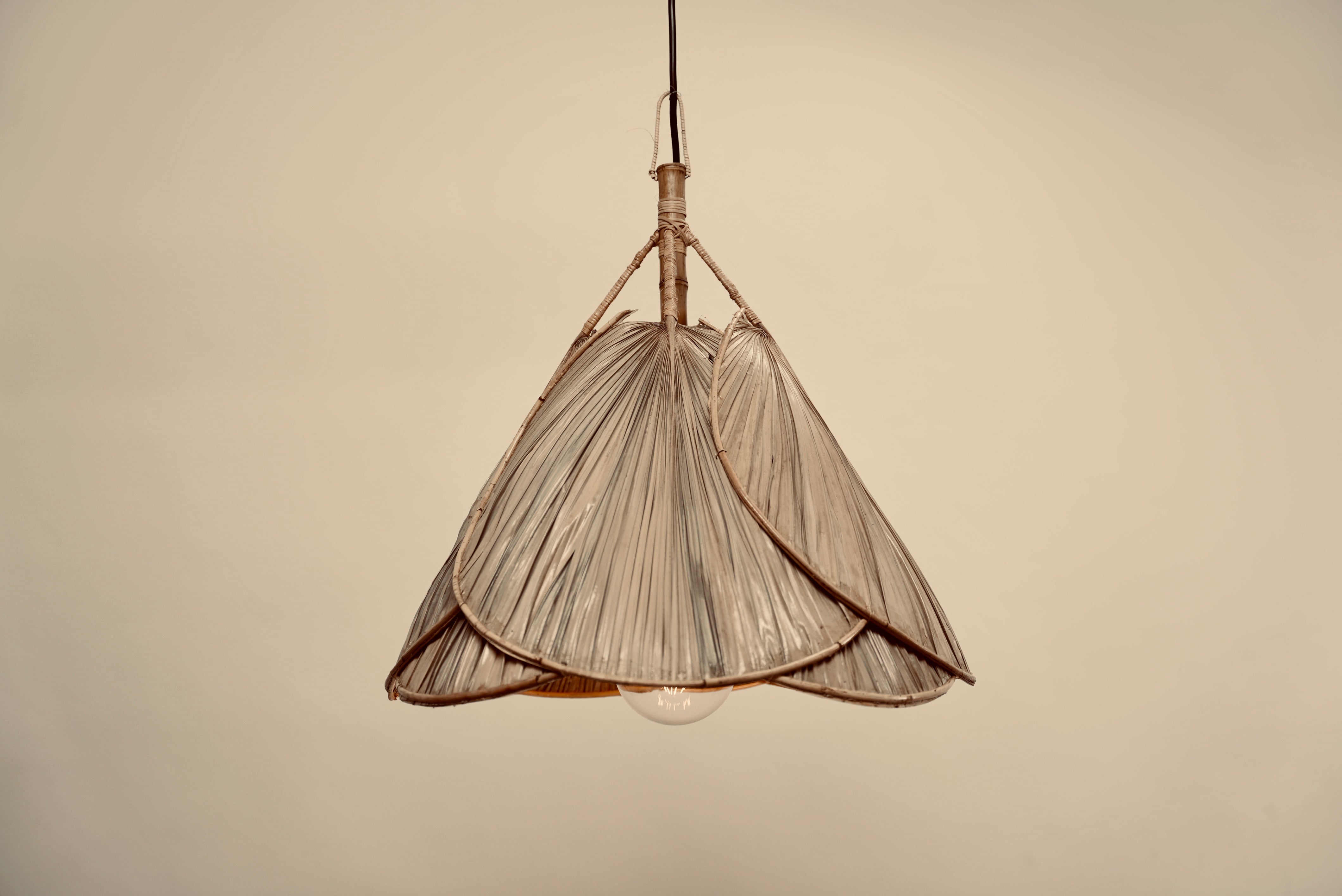The palm leaf lampshade photographed against a neutral background