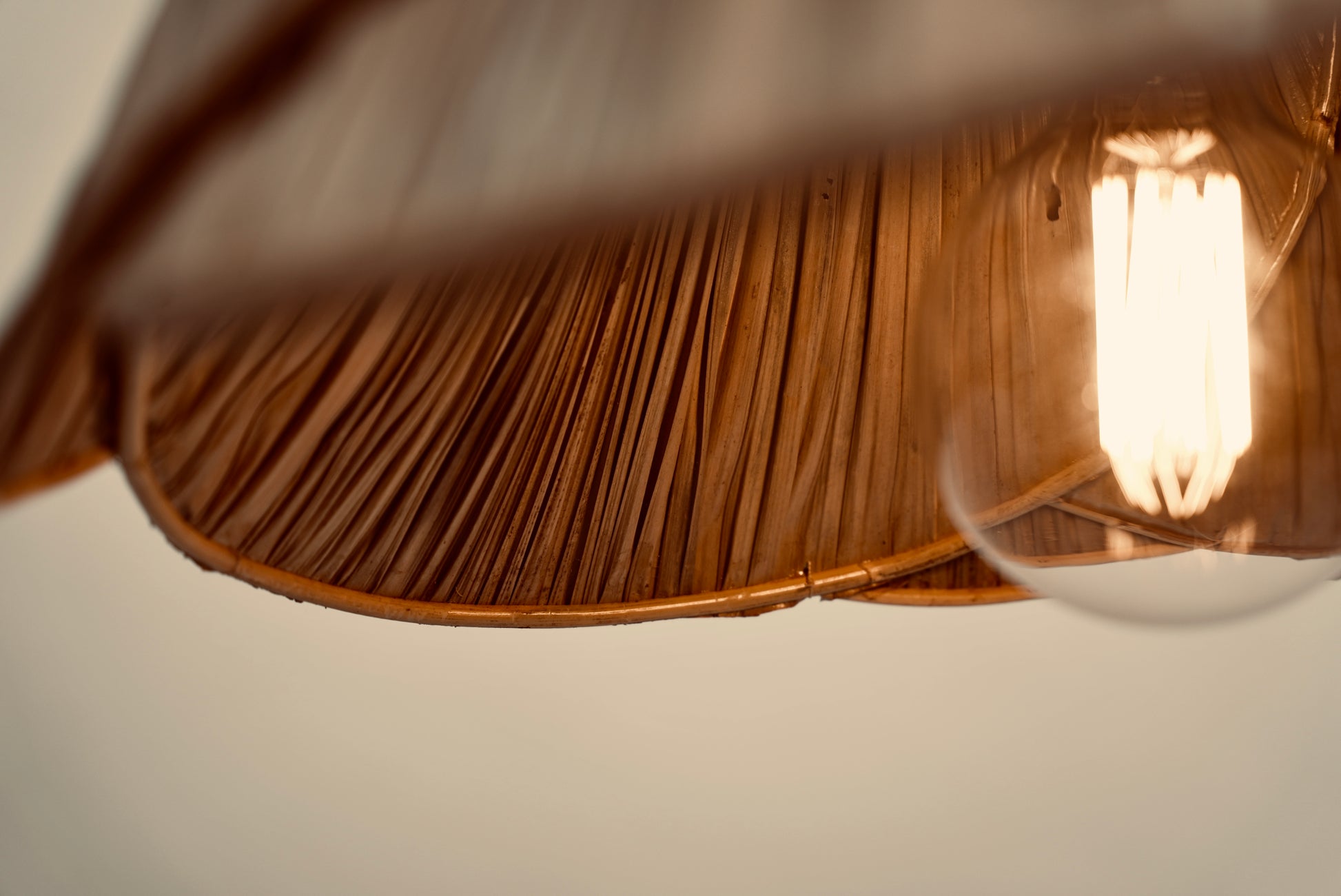 A close-up of the inside of the palm leaf lampshade photographed against a neutral background