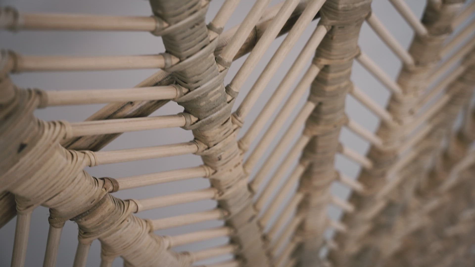Load video: A close-up of the Rattan Ibu headboard photographed against a neutral headboard