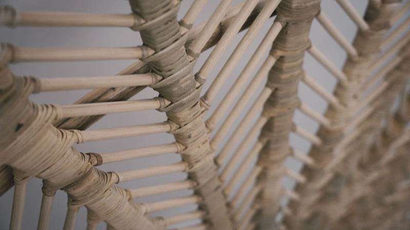 A close-up of the Rattan Ibu headboard photographed against a neutral headboard