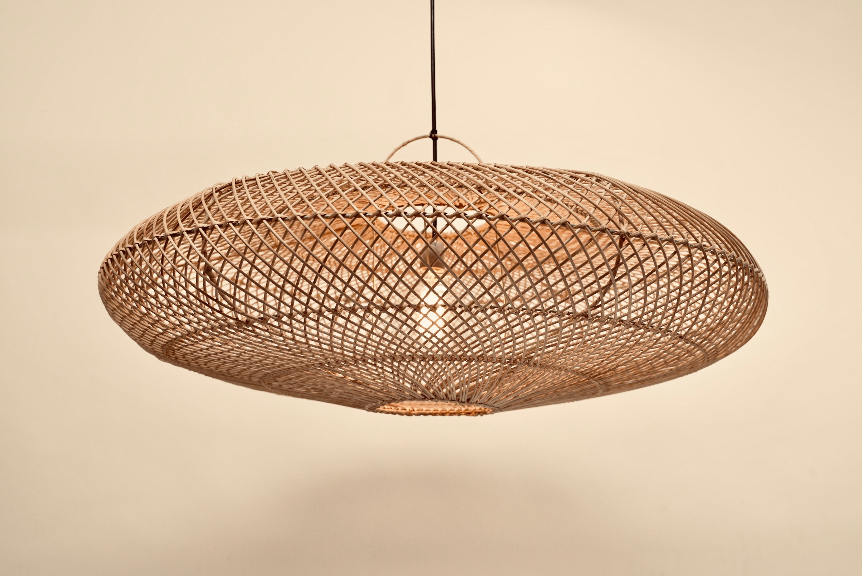 The UFO pendant hanging against a neutral background