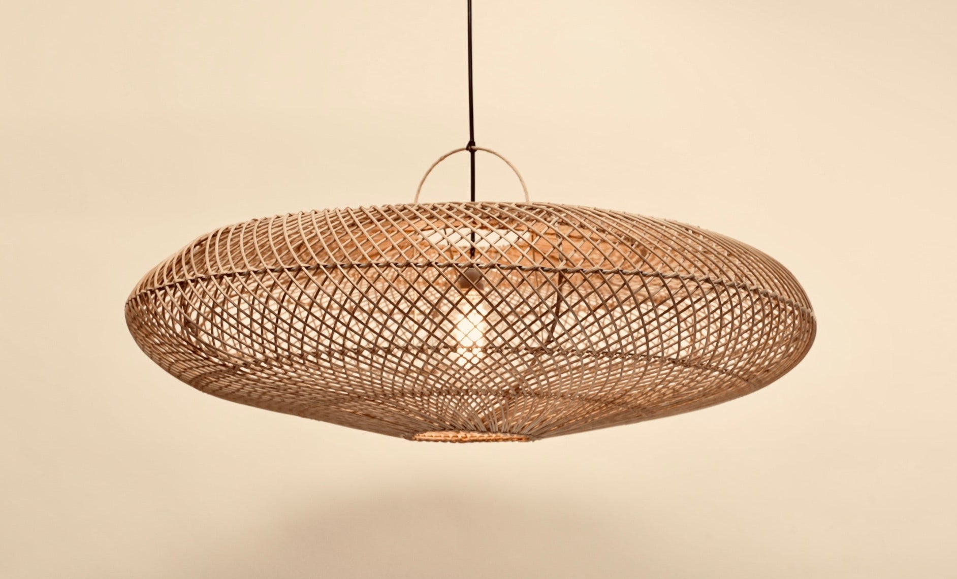 The UFO pendant hanging against a neutral background