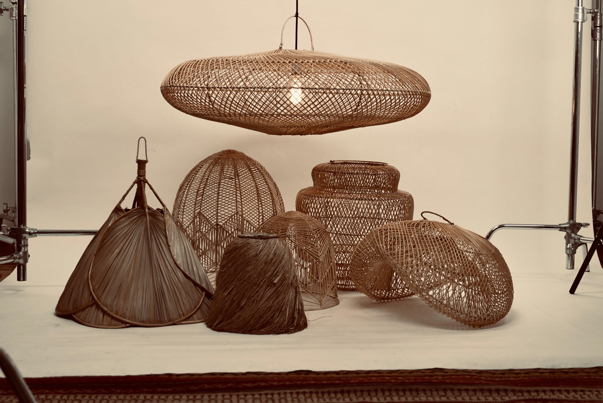 The UFO pendant hanging above a bunch of our other local lampshades against a neutral background