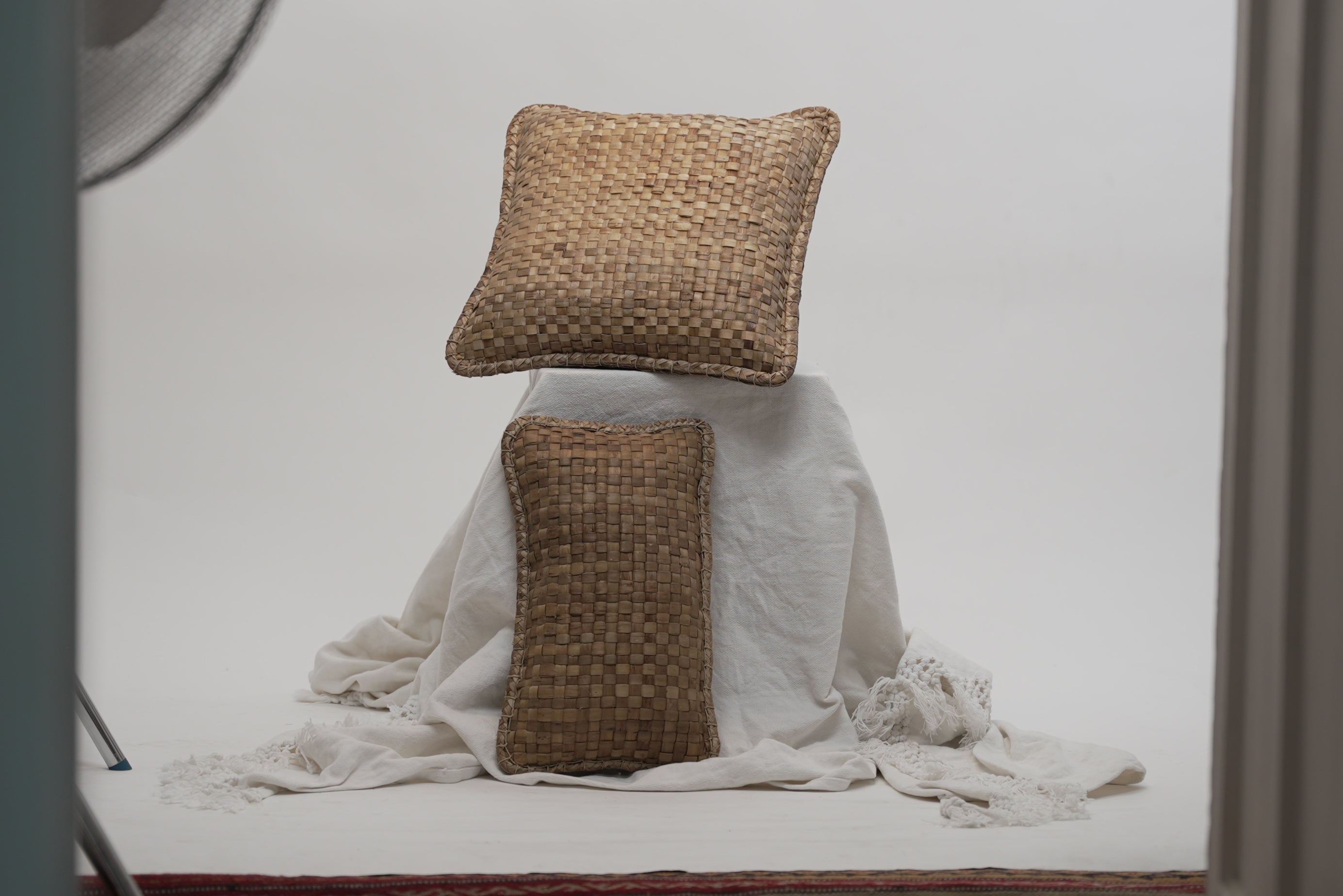 Two crispy woven cushions in different sizes photographed against a neutral background