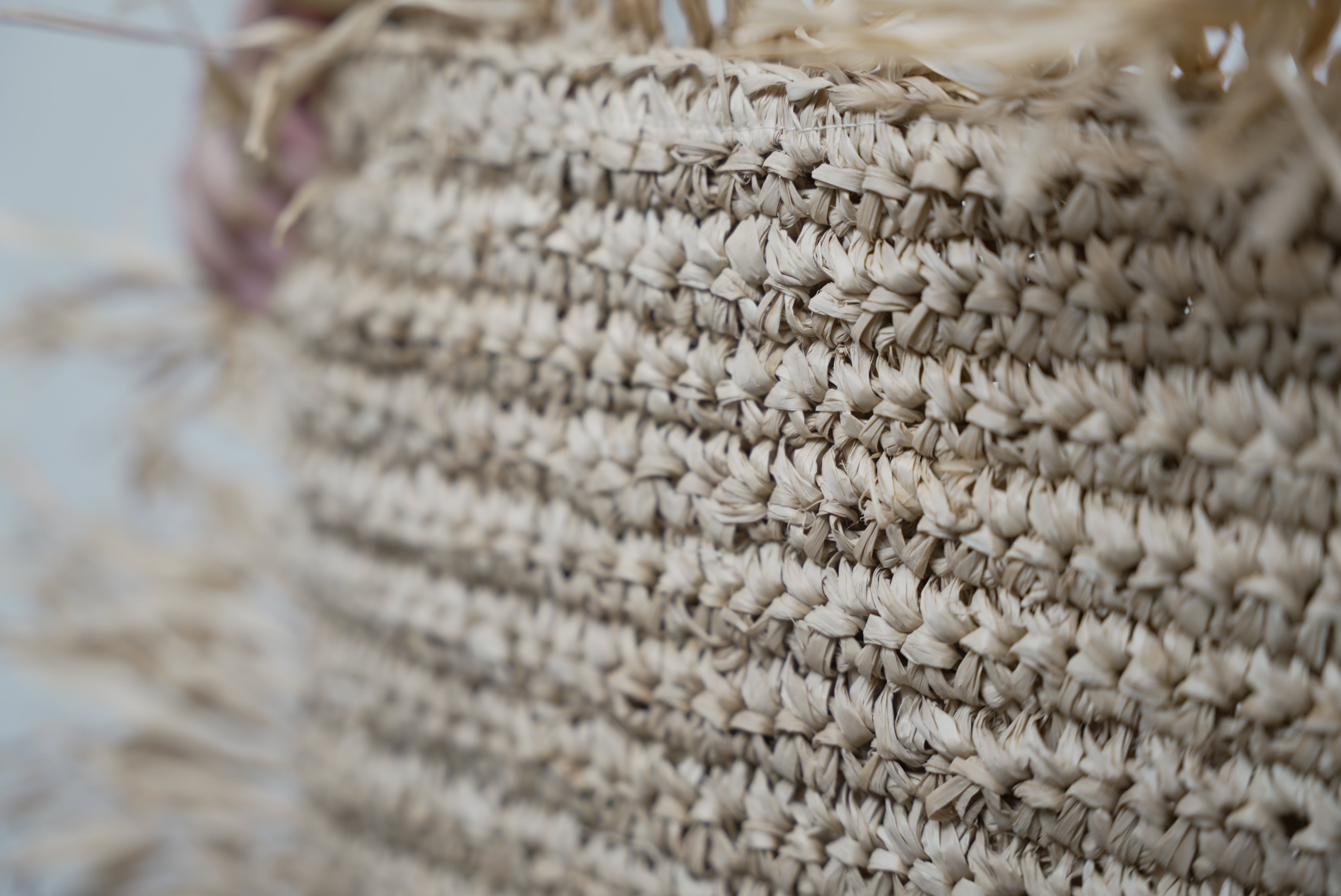 A close-up of the Raffia cushion cover showcasing the intricate weaving