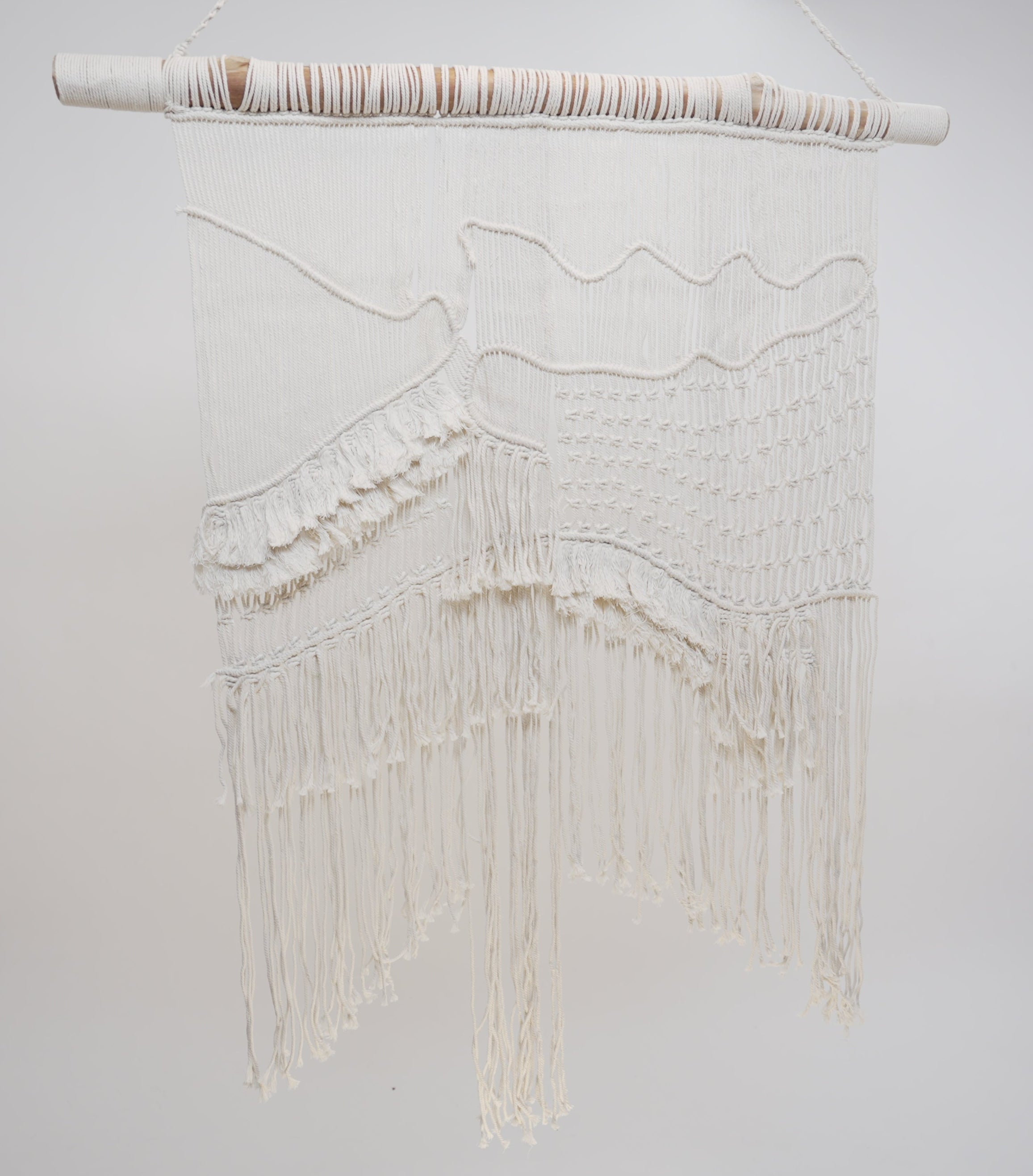 The macrame wall hanger photographed against a neutral background