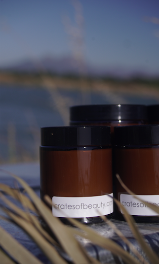 Close-up of soy candles in amber glass jars photographed outside
